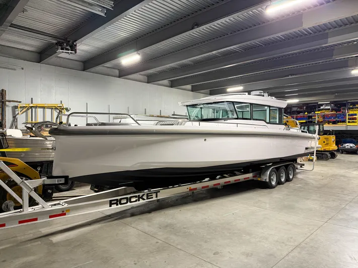  Yacht Photos Pics 2021 Axopar 37 XC CROSS CABIN boat on trailer in indoor storage facility.