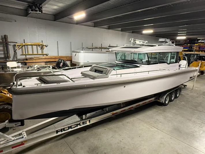  Yacht Photos Pics 2021 Axopar 37 XC CROSS CABIN boat on trailer in indoor storage.