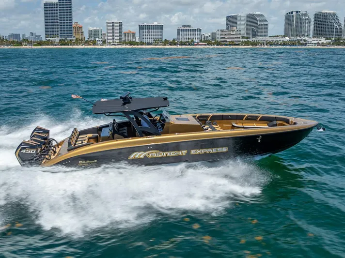 Perla Bianca II Yacht Photos Pics 2023 Midnight Express 43 Open boat cruising on ocean near city skyline.