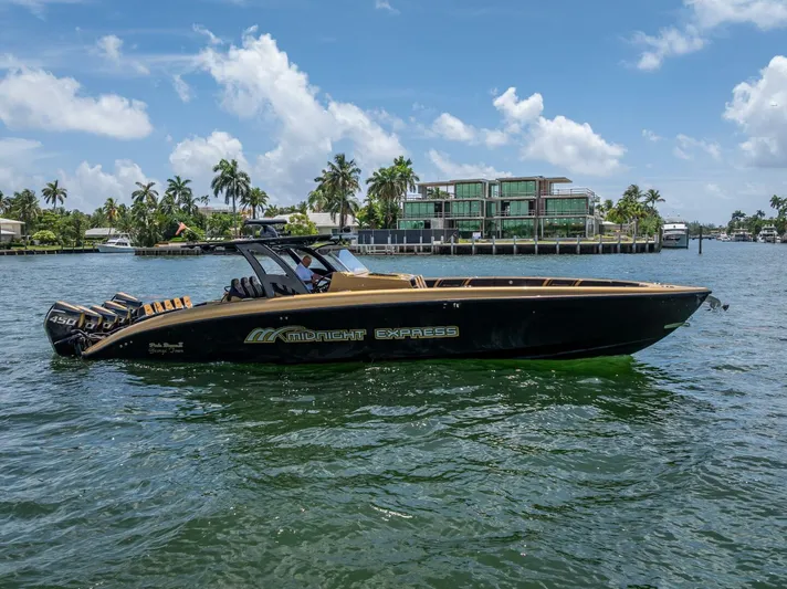 Perla Bianca II Yacht Photos Pics 2023 Midnight Express 43 Open boat cruising on a sunny day near waterfront homes.