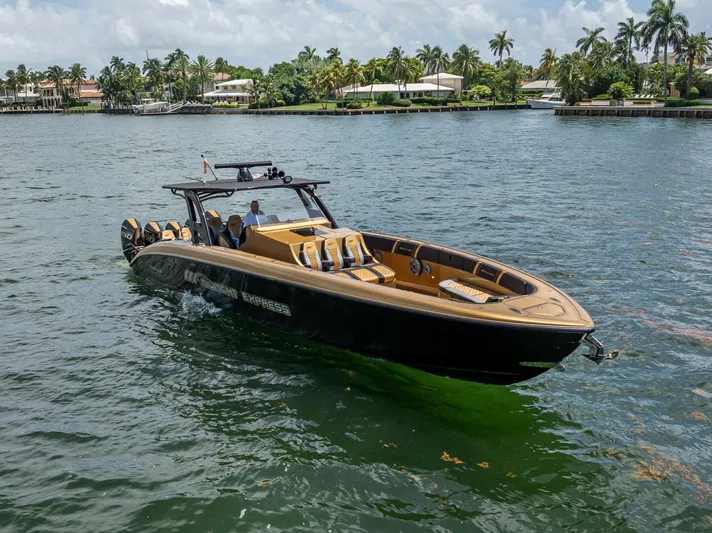 Perla Bianca II Yacht Photos Pics 2023 Midnight Express 43 Open boat cruising on a scenic waterway with palm trees.