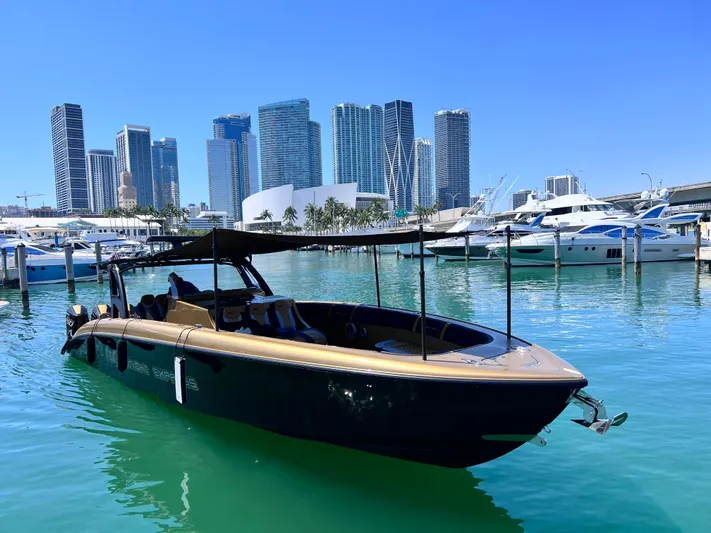 Perla Bianca II Yacht Photos Pics 2023 Midnight Express 43 Open boat docked in a marina with city skyline backdrop.