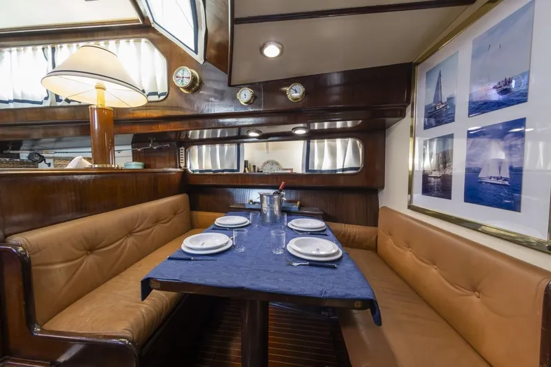  Yacht Photos Pics Luxurious dining area in 1982 Benetti Sail Division 16m Motorsailer, featuring elegant wood and nautical decor.