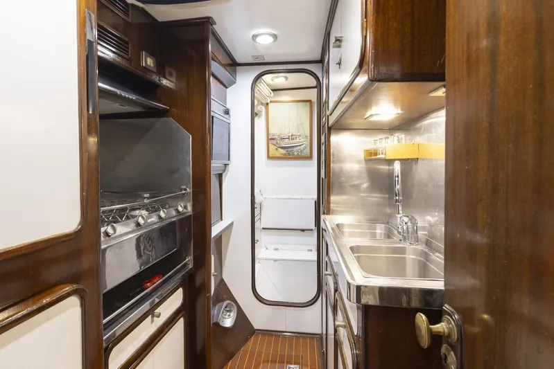  Yacht Photos Pics Luxurious 1982 Benetti Sail Division 16m Motorsailer kitchen with wood and stainless steel finishes.