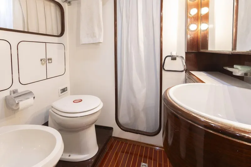  Yacht Photos Pics Luxurious bathroom in 1982 Benetti Sail Division 16m Motorsailer, featuring elegant wood accents.