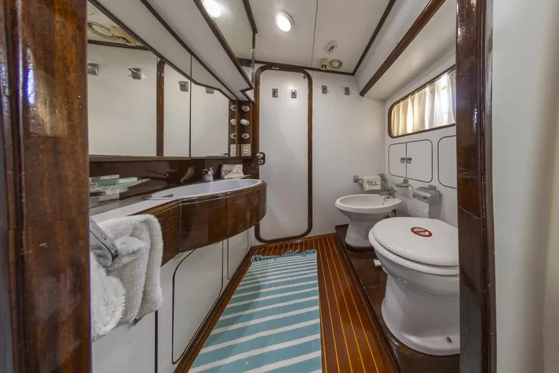  Yacht Photos Pics Luxurious bathroom in 1982 Benetti Sail Division 16m Motorsailer with wood accents and modern fixtures.