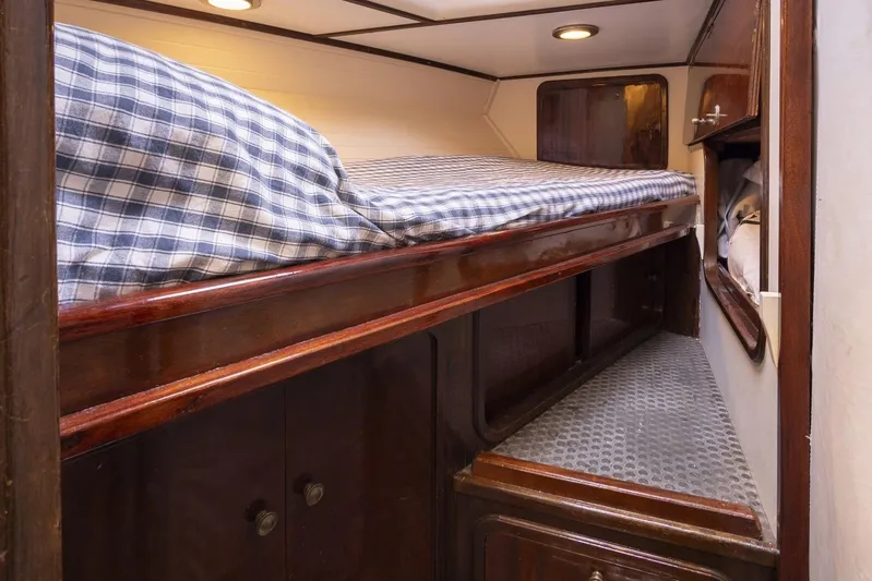  Yacht Photos Pics Cozy cabin interior of 1982 Benetti Sail Division 16m Motorsailer with wooden finish and plaid bedding.