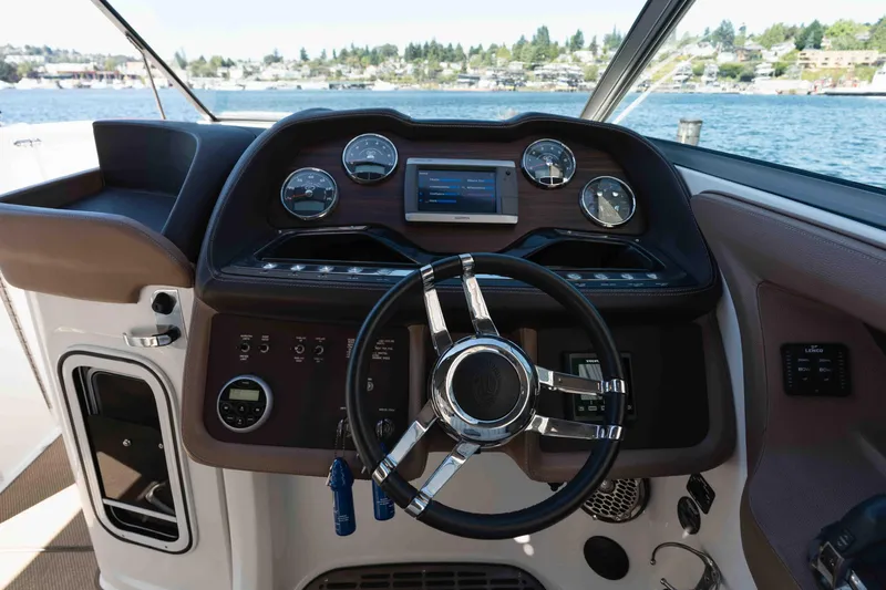  Yacht Photos Pics Steering console of a 2013 Cobalt 336 boat with gauges and controls, overlooking water.