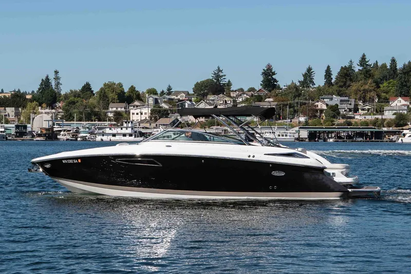  Yacht Photos Pics 2013 Cobalt 336 boat cruising on a scenic lake with houses in the background.