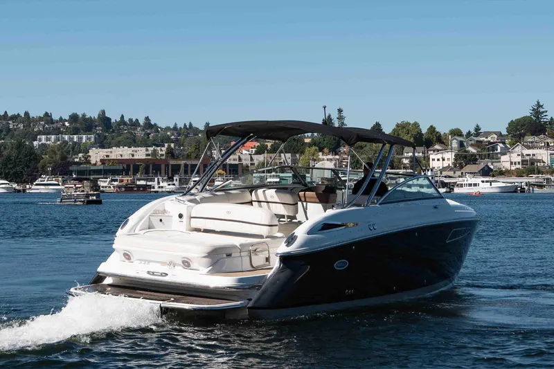  Yacht Photos Pics 2013 Cobalt 336 boat cruising on a scenic lake with waterfront buildings.