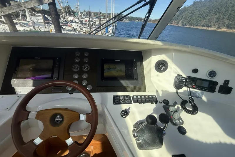  Yacht Photos Pics Cockpit view of 2000 Royal Pacific 476 Sport Cruiser with steering wheel and navigation controls.