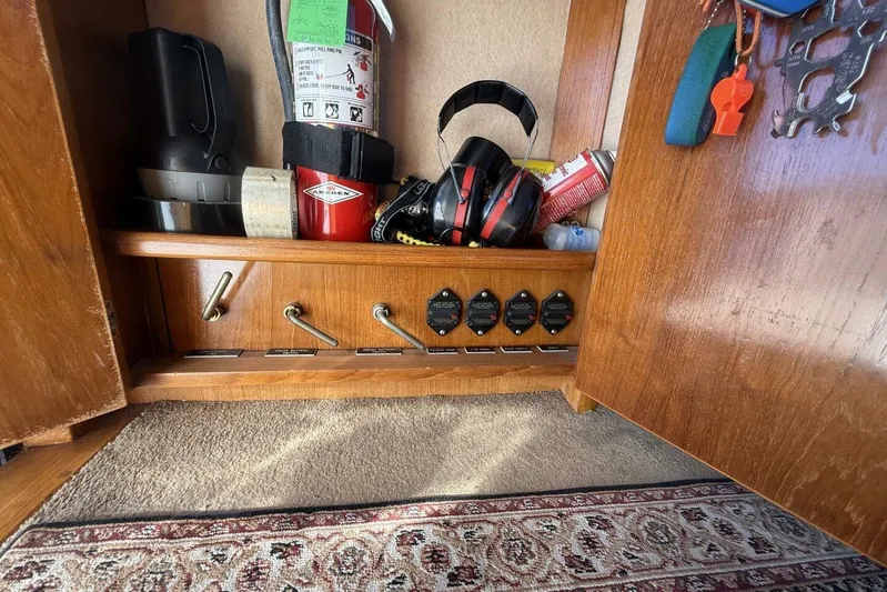  Yacht Photos Pics Storage compartment in a 2000 Royal Pacific 476 Sport Cruiser with safety equipment and controls.