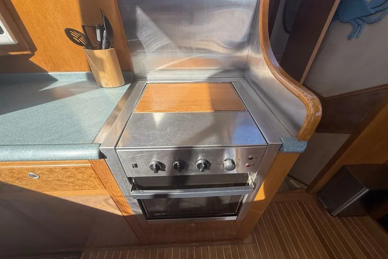  Yacht Photos Pics Galley kitchen in 2000 Royal Pacific 476 Sport Cruiser with stove and utensils.