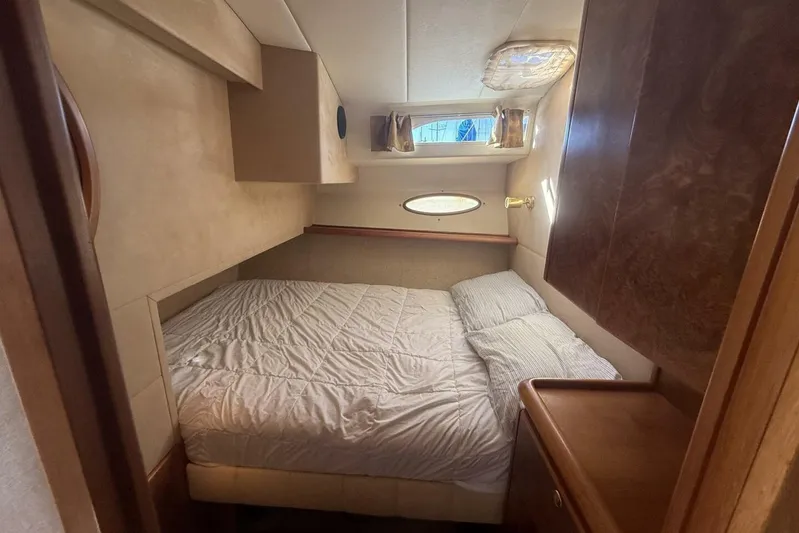  Yacht Photos Pics Cozy cabin interior of 2000 Royal Pacific 476 Sport Cruiser with bed and wooden cabinetry.