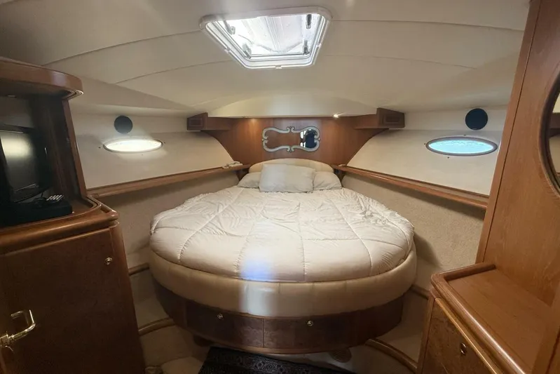  Yacht Photos Pics Luxurious cabin interior of 2000 Royal Pacific 476 Sport Cruiser with cozy bed and wood accents.