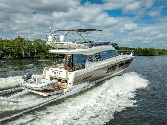 Miss Zoe Yacht Photos Pics Prestige 500 Fly 2014 yacht cruising on a scenic river under a cloudy sky.