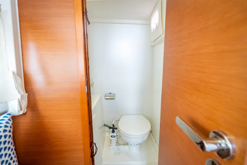 Miss Zoe Yacht Photos Pics Compact bathroom on 2014 Prestige 500 Fly yacht with wooden door and white fixtures.