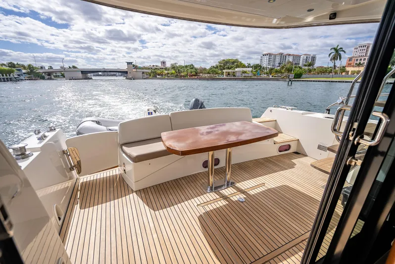 Miss Zoe Yacht Photos Pics Prestige 500 Fly 2014 yacht deck with seating and table, overlooking scenic waterfront.
