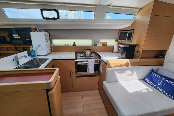 Fred's Dream Yacht Photos Pics Modern kitchen interior of 2020 Jeanneau Sun Odyssey 410 yacht with wooden cabinetry.