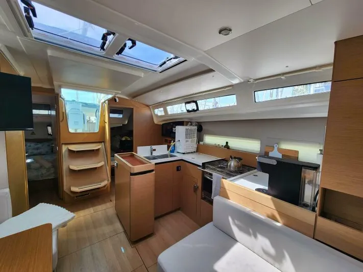 Fred's Dream Yacht Photos Pics Interior of 2020 Jeanneau Sun Odyssey 410 sailboat, featuring modern kitchen and seating area.