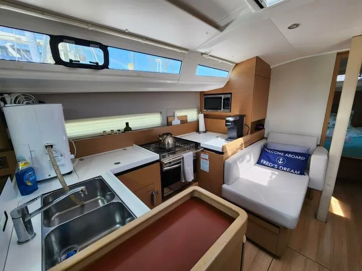 Fred's Dream Yacht Photos Pics Interior of 2020 Jeanneau Sun Odyssey 410 yacht, featuring modern kitchen and cozy seating area.