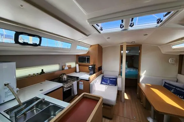 Fred's Dream Yacht Photos Pics Interior of 2020 Jeanneau Sun Odyssey 410 yacht, featuring modern kitchen and seating area.