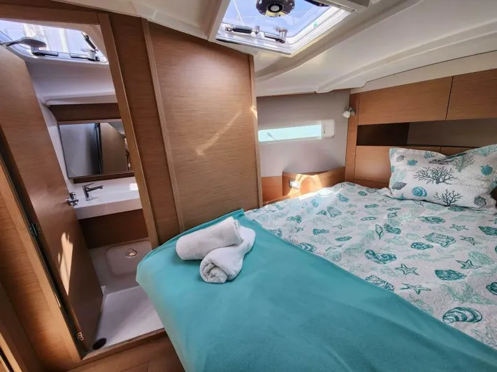 Fred's Dream Yacht Photos Pics Cozy cabin interior of 2020 Jeanneau Sun Odyssey 410 yacht with bed and bathroom.