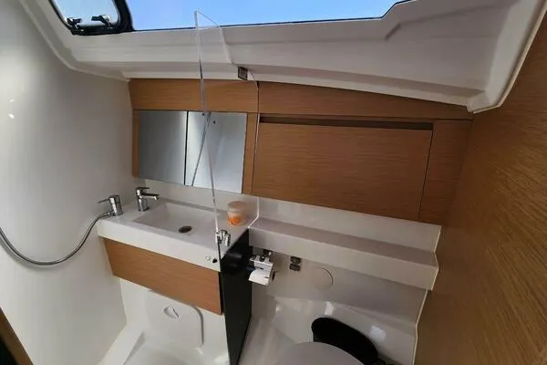 Fred's Dream Yacht Photos Pics Modern bathroom in 2020 Jeanneau Sun Odyssey 410 yacht with sink, mirror, and wooden cabinetry.