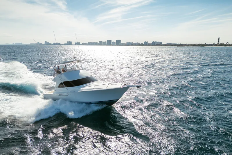 Ring Game Yacht Photos Pics 2008 Viking 42 Convertible yacht cruising on open water with city skyline backdrop.