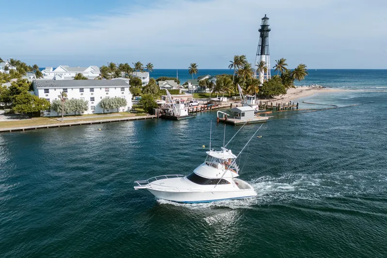 Ring Game Yacht Photos Pics 2008 Viking 42 Convertible yacht cruising near lighthouse and palm trees.