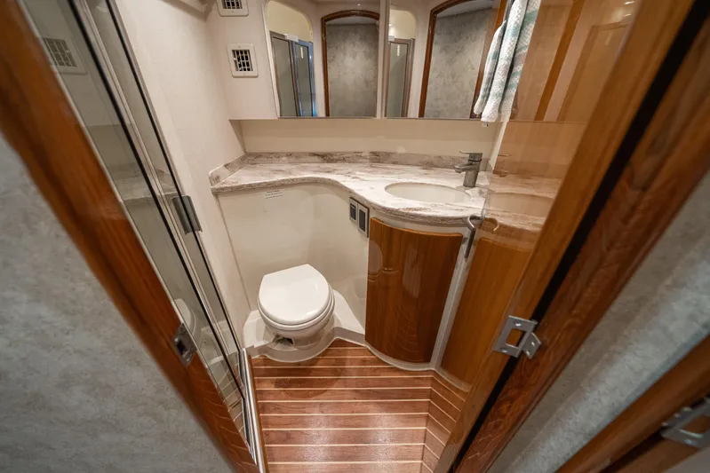 Ring Game Yacht Photos Pics Luxurious bathroom interior of 2008 Viking 42 Convertible yacht with wood accents and modern fixtures.