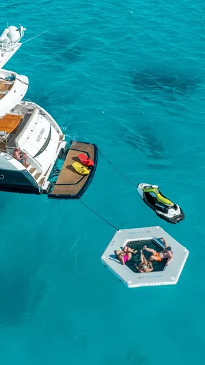 Azzurro Yacht Photos Pics Luxury Sunseeker Manhattan 70 yacht with floating platform and jet ski in turquoise waters.