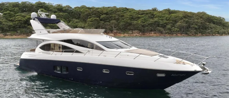 Azzurro Yacht Photos Pics 2009 Sunseeker Manhattan 70 yacht on water, with lush green shoreline in background.