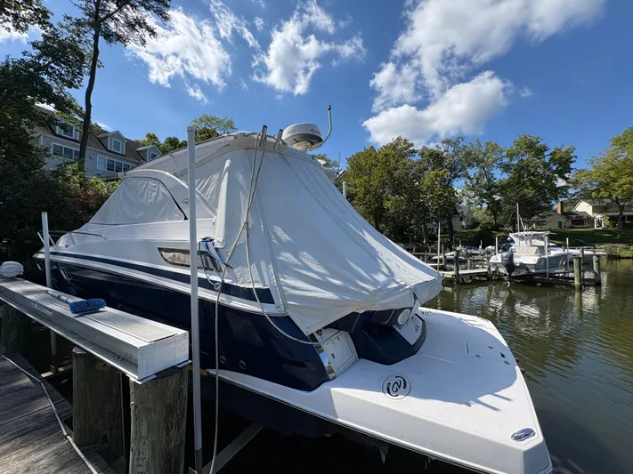 Wining Down Yacht Photos Pics 2016 Regal 35 Sport Coupe docked, covered, under a clear blue sky.
