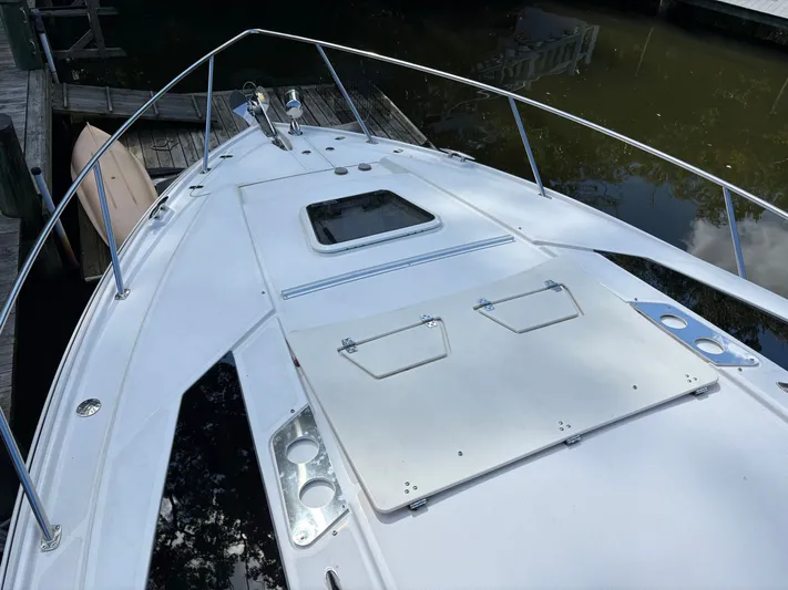 Wining Down Yacht Photos Pics 2016 Regal 35 Sport Coupe boat deck with railing, docked by calm water.