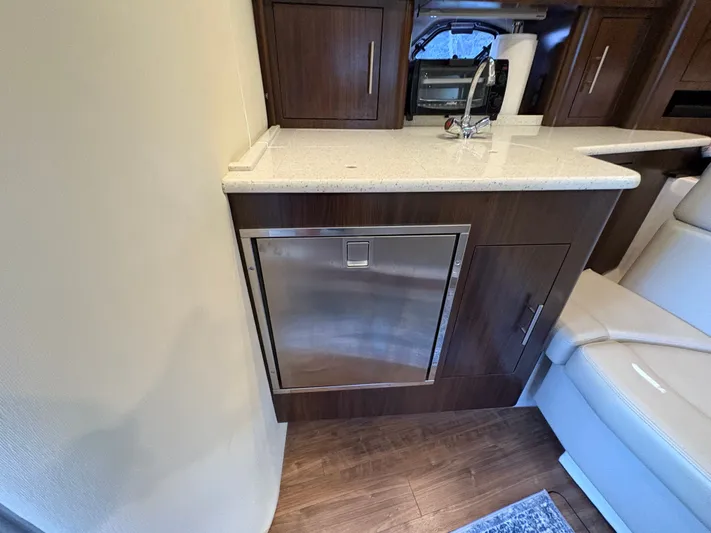 Wining Down Yacht Photos Pics Interior of 2016 Regal 35 Sport Coupe with modern kitchenette and stainless steel appliances.