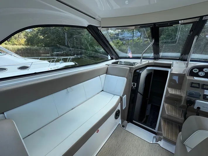 Wining Down Yacht Photos Pics Interior of 2016 Regal 35 Sport Coupe, featuring seating and control panel.