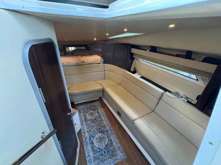 Wining Down Yacht Photos Pics Interior of 2016 Regal 35 Sport Coupe with beige seating and cozy cabin layout.
