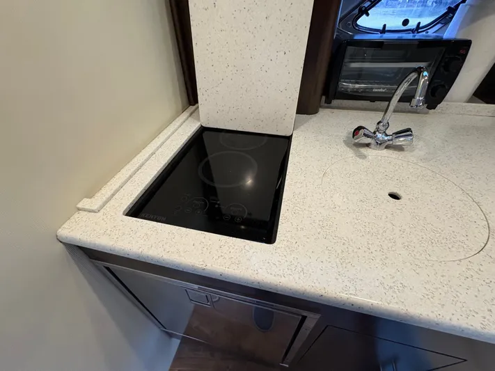 Wining Down Yacht Photos Pics Modern kitchen area in 2016 Regal 35 Sport Coupe with stovetop and sink.