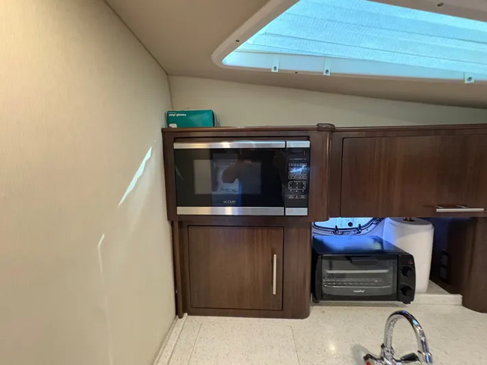 Wining Down Yacht Photos Pics 2016 Regal 35 Sport Coupe interior kitchen with microwave, toaster oven, and sink.