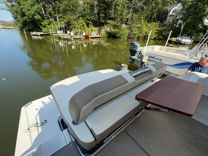 Wining Down Yacht Photos Pics 2016 Regal 35 Sport Coupe boat with seating and table, docked by a serene lake.