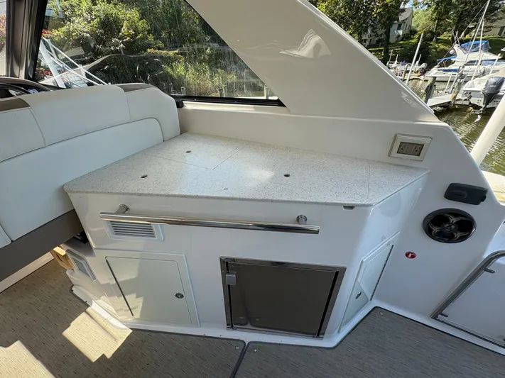 Wining Down Yacht Photos Pics 2016 Regal 35 Sport Coupe interior with kitchenette and seating area.
