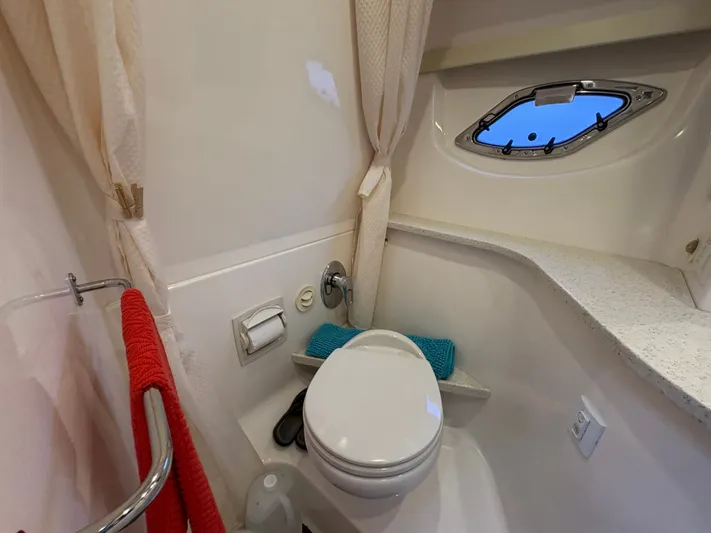 Wining Down Yacht Photos Pics 2016 Regal 35 Sport Coupe bathroom with toilet, porthole, and red towel.