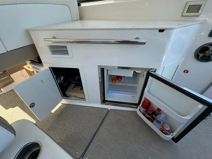 Wining Down Yacht Photos Pics 2016 Regal 35 Sport Coupe interior with open mini fridge and storage compartments.