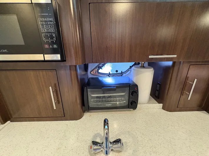 Wining Down Yacht Photos Pics 2016 Regal 35 Sport Coupe kitchen with microwave, toaster oven, and sink.