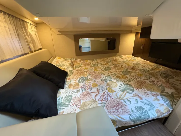 Wining Down Yacht Photos Pics Cozy cabin interior of 2016 Regal 35 Sport Coupe with floral bedding and soft lighting.