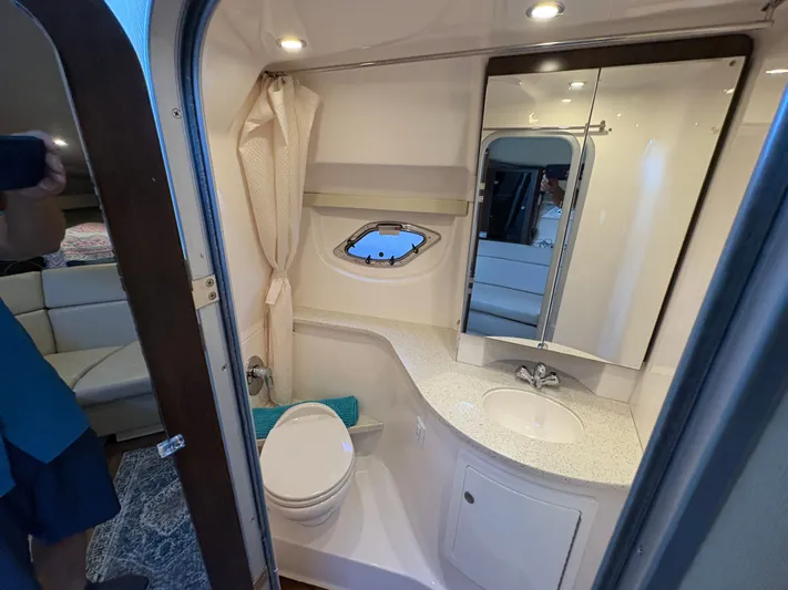Wining Down Yacht Photos Pics Bathroom interior of 2016 Regal 35 Sport Coupe with sink, toilet, and mirror.