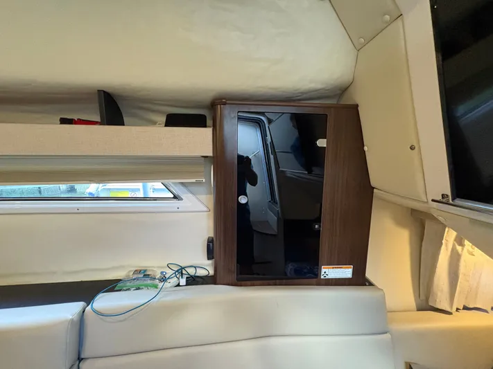 Wining Down Yacht Photos Pics Interior of a 2016 Regal 35 Sport Coupe, featuring a wooden cabinet and seating area.