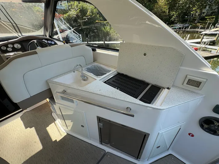 Wining Down Yacht Photos Pics 2016 Regal 35 Sport Coupe interior with kitchenette, sink, and grill.