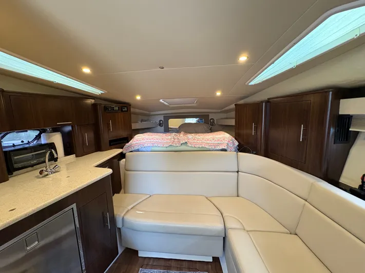 Wining Down Yacht Photos Pics Interior of 2016 Regal 35 Sport Coupe with modern kitchen and cozy seating area.